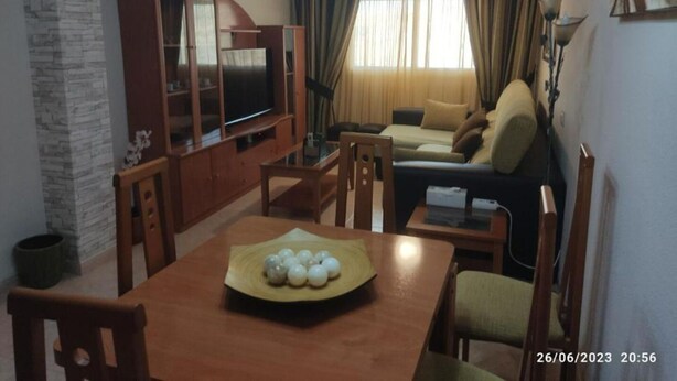 A living room with a TV, sofa, and dining table with decorative balls. - Apartamento Villa Inés (Huércal de Almería)