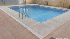 A rectangular swimming pool with a metal ladder, surrounded by a tiled deck. - Apartamento Villa Inés (Huércal de Almería)