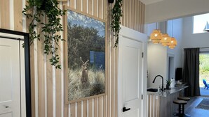A modern kitchen with a large window, a hanging light fixture, and a view of the outdoors. - Drift Inn Duplex B - with hot tub (Ocean Shores)