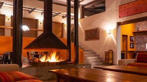 A cozy interior with a fireplace, wooden furniture, and a staircase. - Andenes de Azpitia (Santa Cruz de Flores)