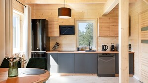 Une cuisine moderne avec des murs en bois, un réfrigérateur noir et un lave-vaisselle.