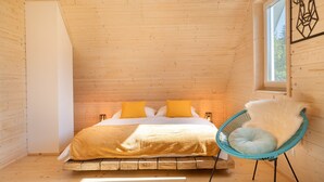 Un intérieur en bois avec un lit, une chaise et une fenêtre.