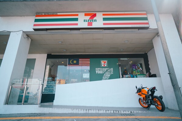 A 7-Eleven store with a motorcycle parked outside. - Cozy studio suite at D majesti (Kuala Lumpur)