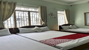 A hotel room with two beds, a red and white patterned bedspread, and a window with metal bars. - OYO 1206 Toan Thang Homestay (Xuan Huong - Da Lat)