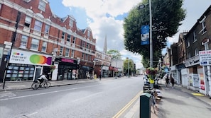 A street view with a 'Barnard Marcus' sign, a 'Dry Cleaner' sign, and a 'For Sale' sign. - 1-bed Apartment in Ealing (London)