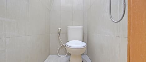 A small, modern bathroom with a toilet, a shower, and a toilet paper holder.