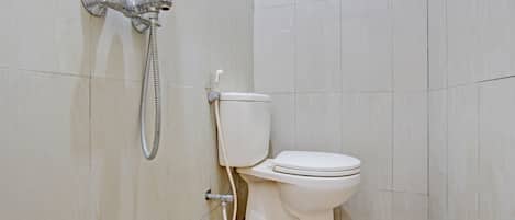 A small, clean bathroom with a toilet and a shower unit.