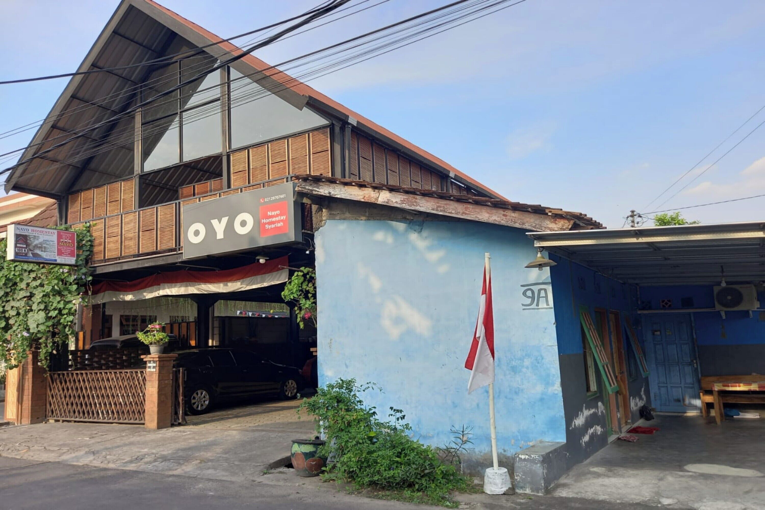A two-story building with a sign reading "OYO" and a flagpole with a flag.