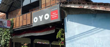 A two-story building with a sign reading "OYO Nayo Homestay Syannah".
