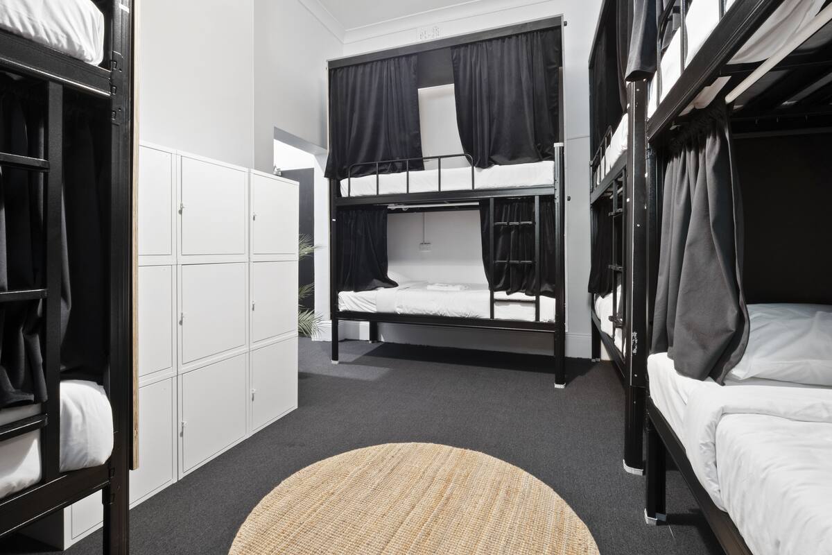 A bunk bed room with a wardrobe and a round rug.