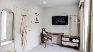 A modern bedroom with a large mirror, a desk with a chair, a TV, and a wardrobe. - Your Apartment Tooting (London)