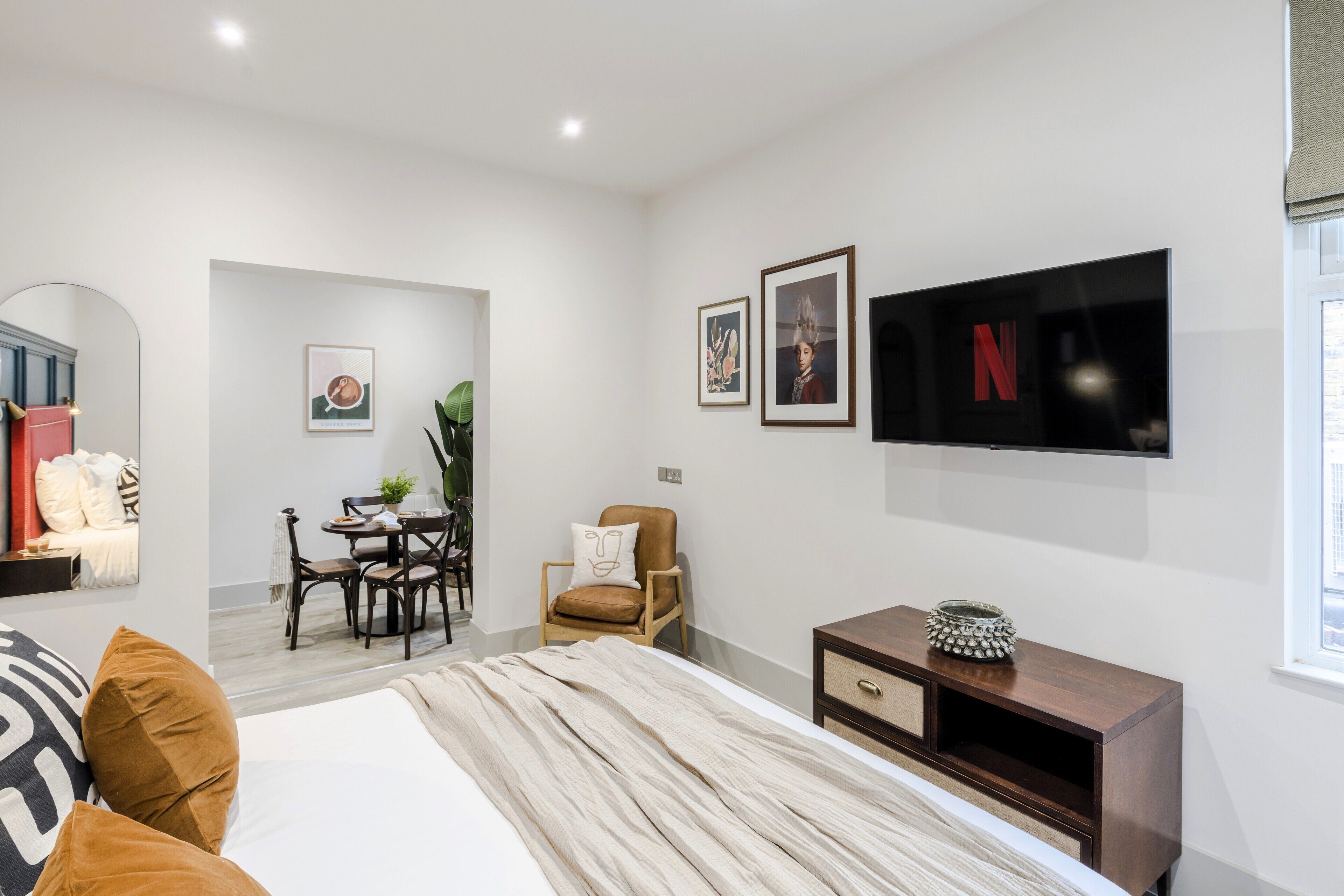 Une chambre moderne avec un grand lit, une télévision, un bureau et une chaise.