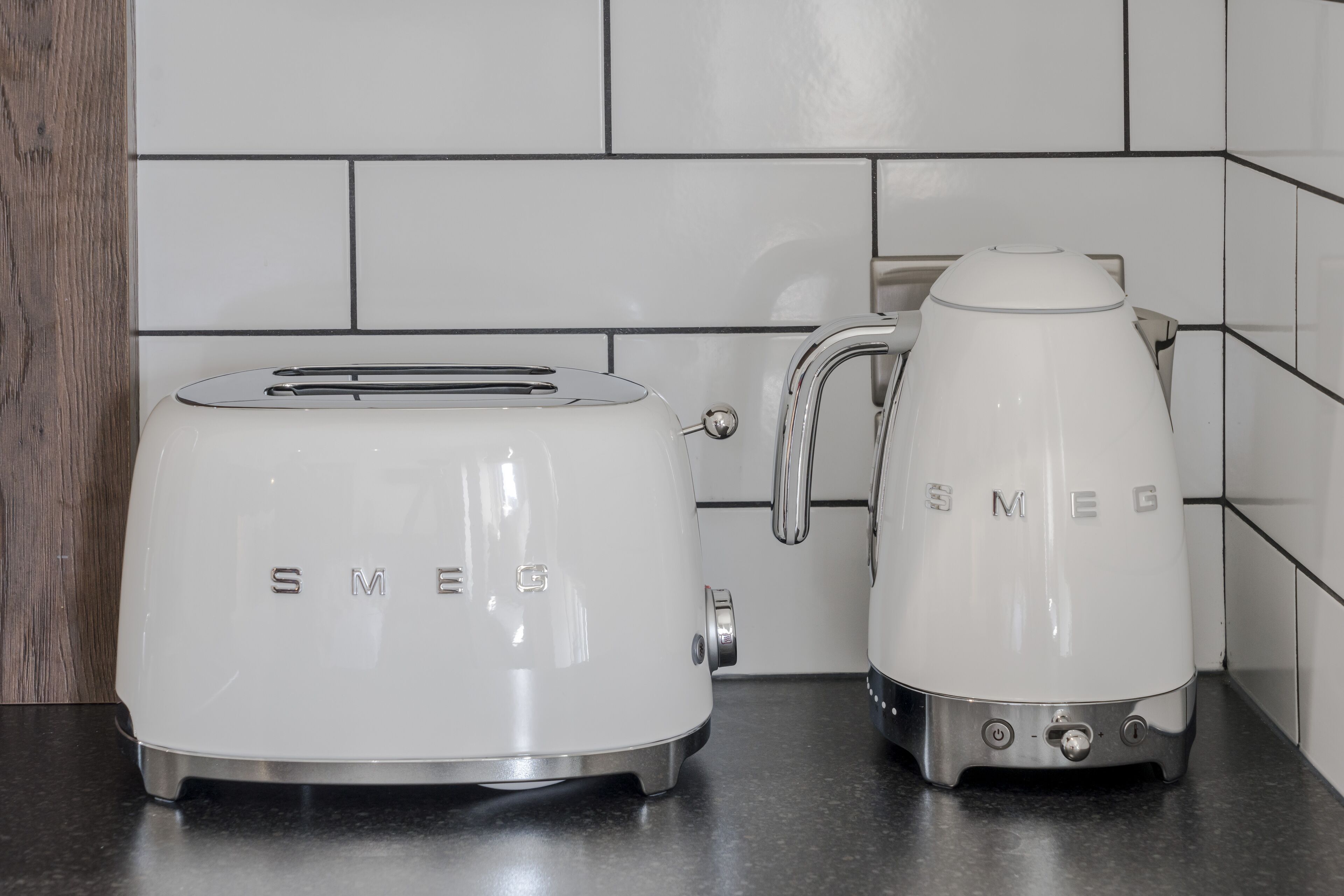 A kitchen with a white toaster and a white electric kettle on a countertop.