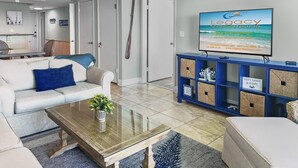 A modern living room with a sofa, coffee table, and a television displaying the logo of Legacy Vacations.
