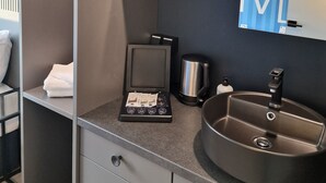 A modern bathroom with a built-in microwave, a coffee maker, and a sink. - [BEE]VILLAGE MESSEHOTEL HANNOVER-LAATZEN. (Laatzen)