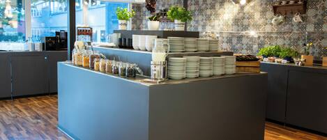 Una cocina moderna con una isla central, suelo de madera y plantas decorativas.