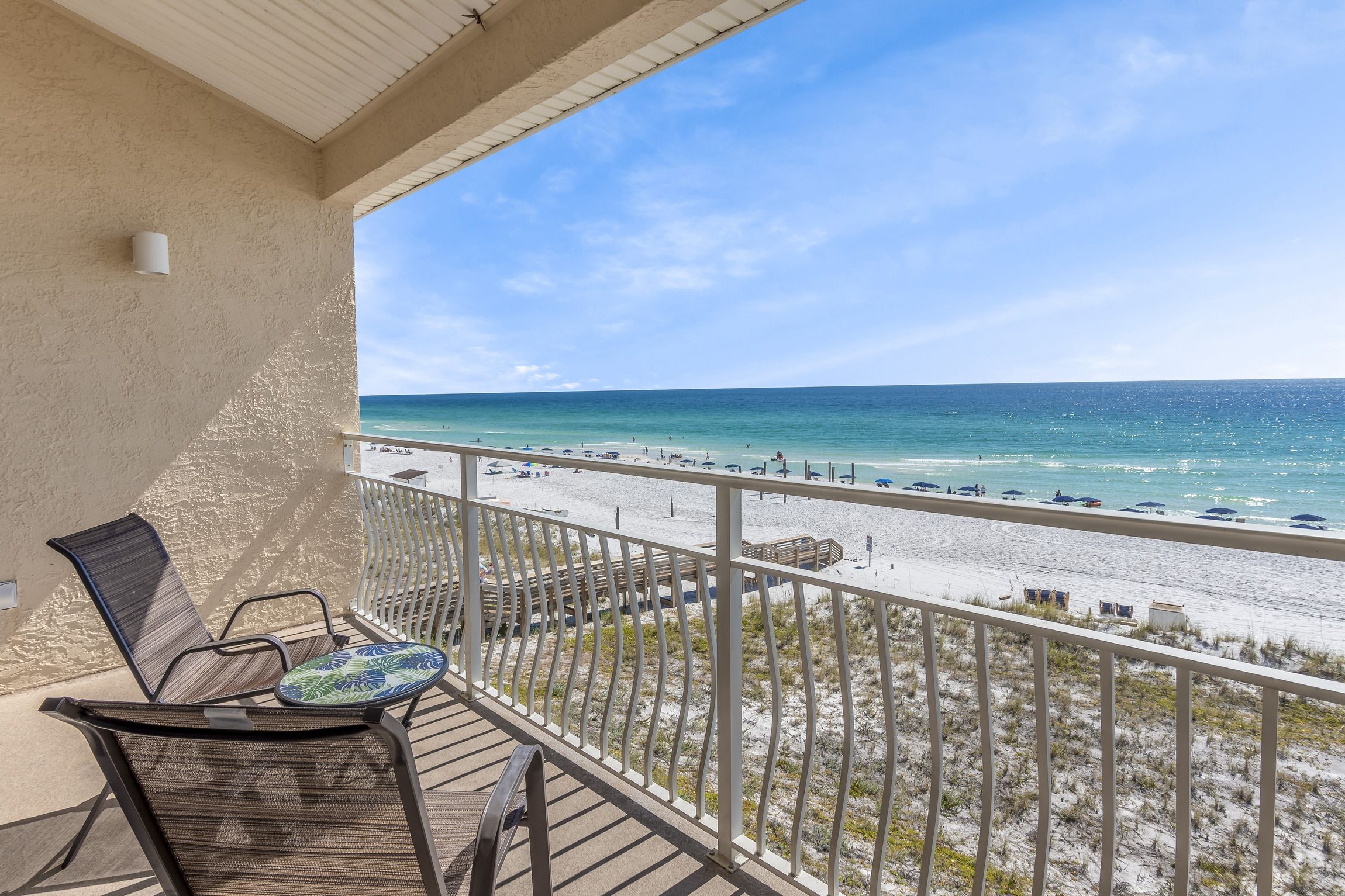 A balcony with a view of a beach and ocean.
