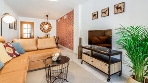 Una sala de estar con sofá, televisor y objetos decorativos.