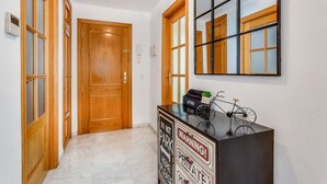 Un pasillo con puertas de madera, un armario negro con una señal de advertencia y una bicicleta encima.