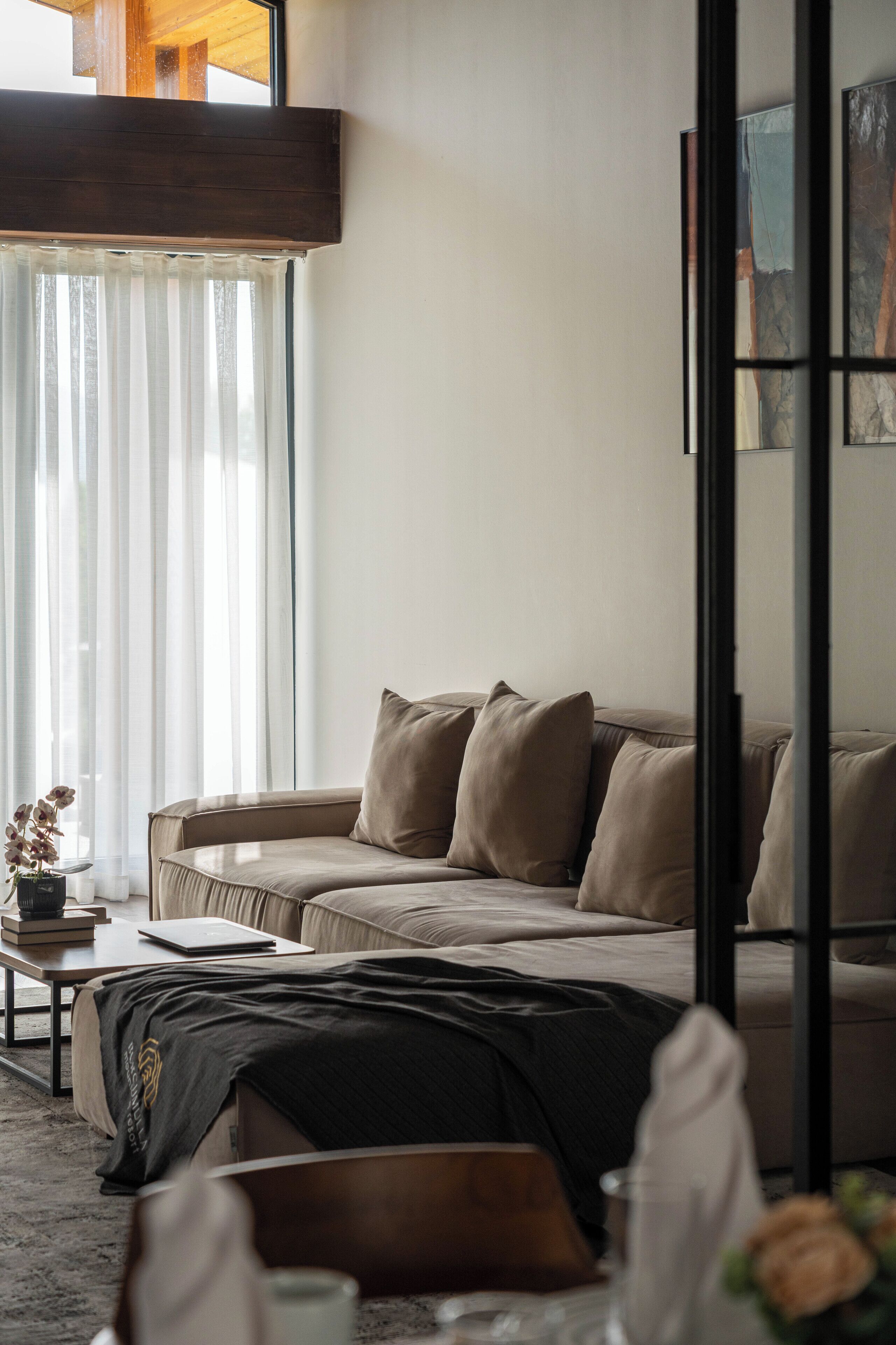 A modern living room with a sofa, a coffee table, and a laptop.