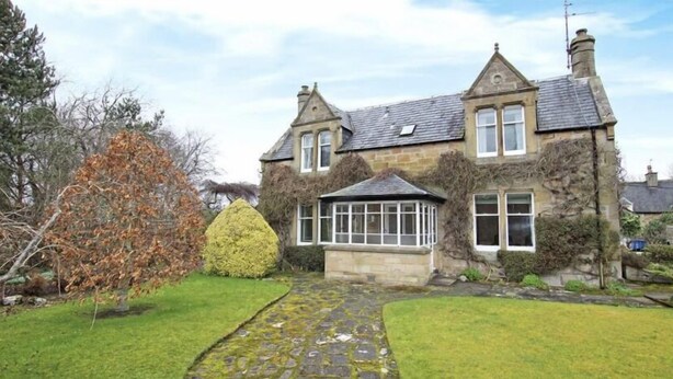 A stone house with a traditional design, featuring a conservatory, a stone pathway, and a well-maintained lawn. - St Duthus Villa Guesthouse (Tain)