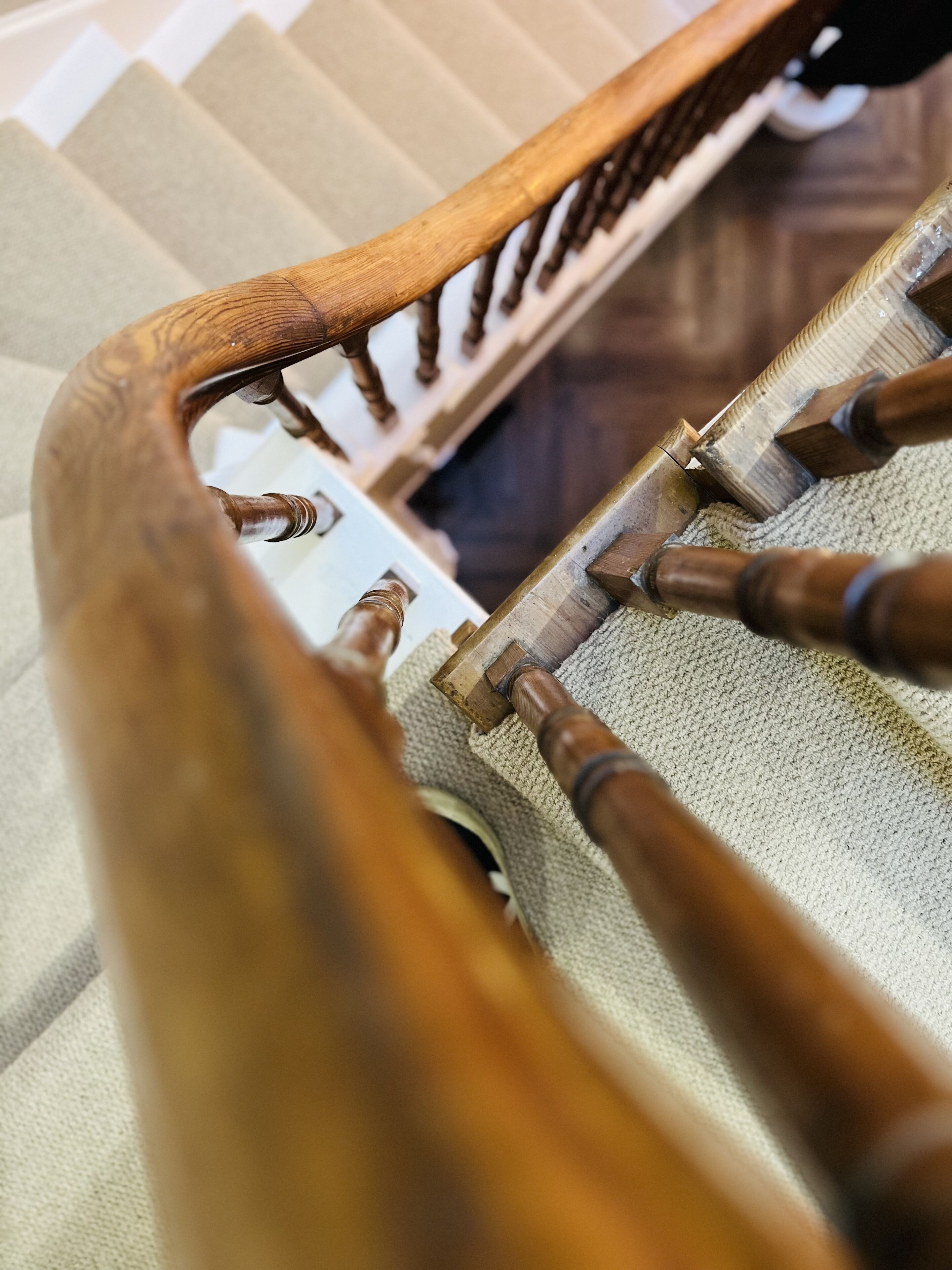 A wooden handrail with a textured grip and a metal handrail.