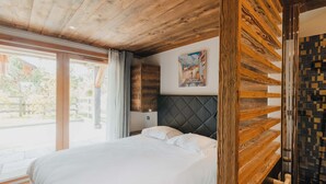 Une chambre à coucher avec un grand lit, une tête de lit en bois et un tableau accroché au mur.
