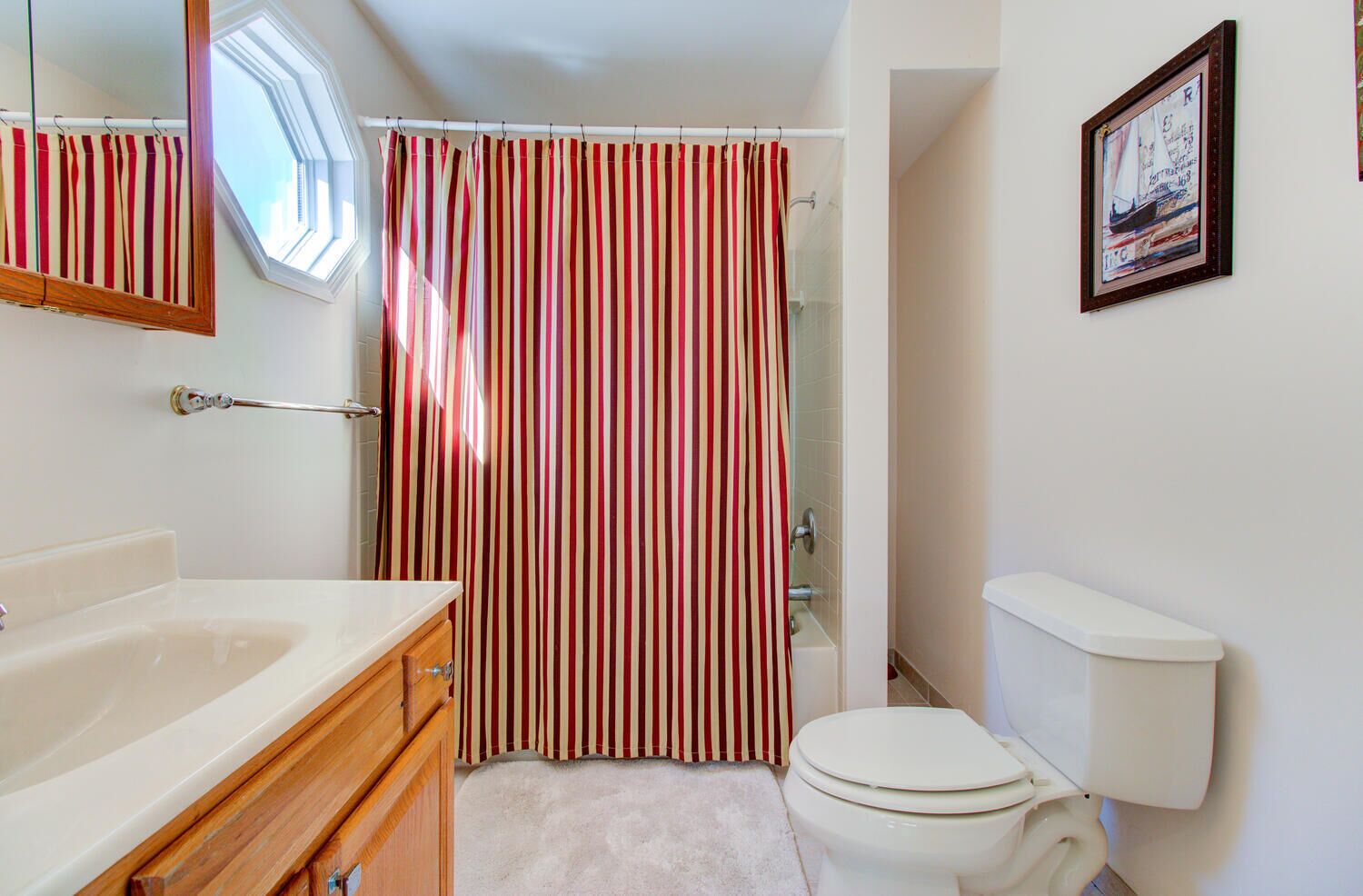 A bathroom with a bathtub, toilet, and a shower curtain.
