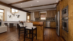 Una cocina moderna con armarios de madera, electrodomésticos de acero inoxidable y una isla central.