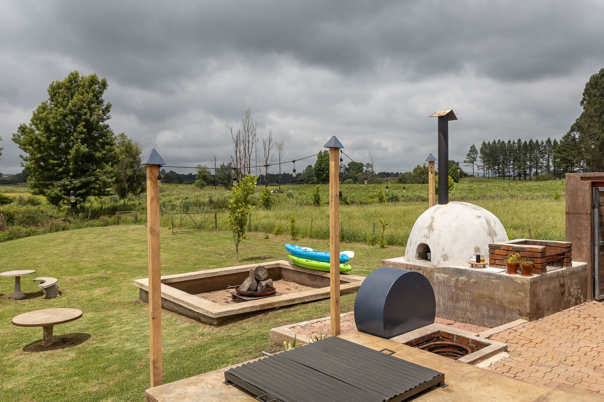 Un patio al aire libre con una parrilla, un área de estar y un pequeño bote.