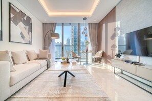 Ein modernes Wohnzimmer mit einer Couch, einem Couchtisch und einem Fernseher auf einem Standfuß.
