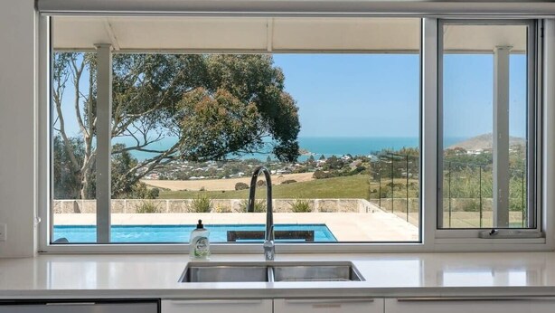 A kitchen with a view of a swimming pool and landscape. - Encounter Blue Victor Harbor Retreat: Secluded Pool (Waitpinga)