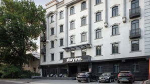 A multi-story hotel with a 'Stay Inn' sign, featuring a classic architectural style with symmetrical windows and balconies. - StayInn City Center (Tashkent)
