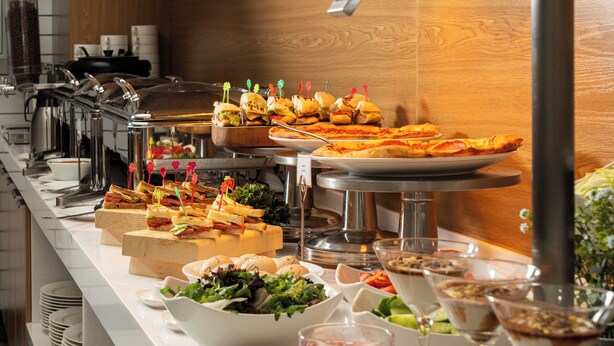 A buffet setup with various food items and a salad bar. - StayInn City Center (Tashkent)