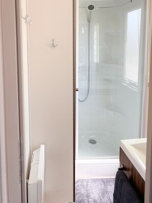 Chuveiro, toalhas de banho, papel higiênico 