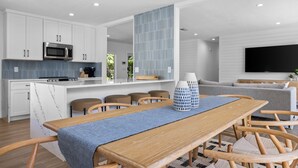 A modern kitchen with white cabinetry, a built-in microwave, and a central island.