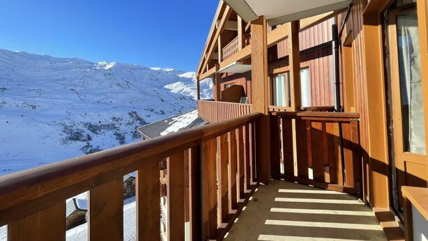 A wooden balcony with a view of a snowy mountain landscape. - 10m from ski slopes, 7th floor, view mountain, balcony, tv, 25m², Les Menuires (Les Menuires)