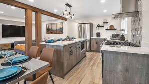 A modern kitchen with wooden cabinets, a stainless steel refrigerator, and a central island. - Pacific Northwest Retreat Duplex 3min from Seattle by RedAwning (Tukwila)