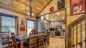 Un interior de madera con comedor, cocina y escalera.