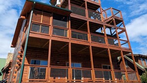 Un edificio de madera de varios pisos con balcones y ventanas amplias.