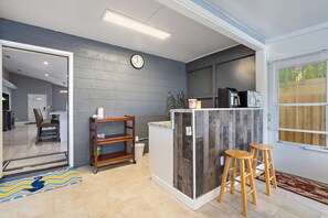 Modern kitchen with island, wooden stools, and stainless steel appliances.
