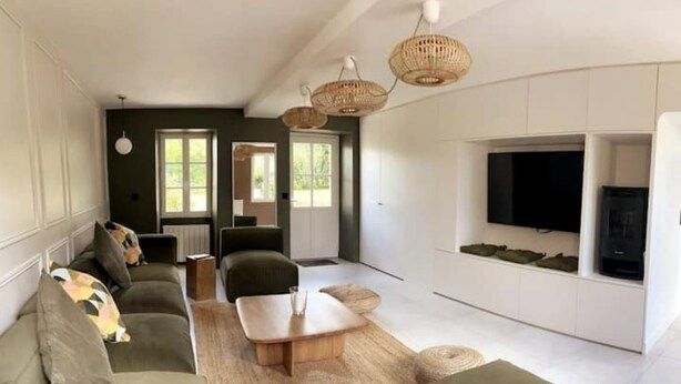 Una sala de estar moderna con un juego de sofá, una mesa de centro y un televisor montado en la pared.