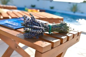 Una mesa de madera con un ramo de lavanda y un libro azul.