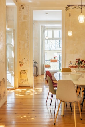 Ein Essbereich mit Holzboden, einem Tisch mit Stühlen und hängenden Pendelleuchten.