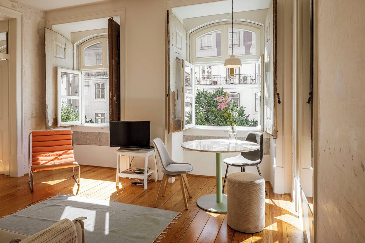 Een moderne woonkamer met een televisie, een ronde tafel en een gezellige zithoek.