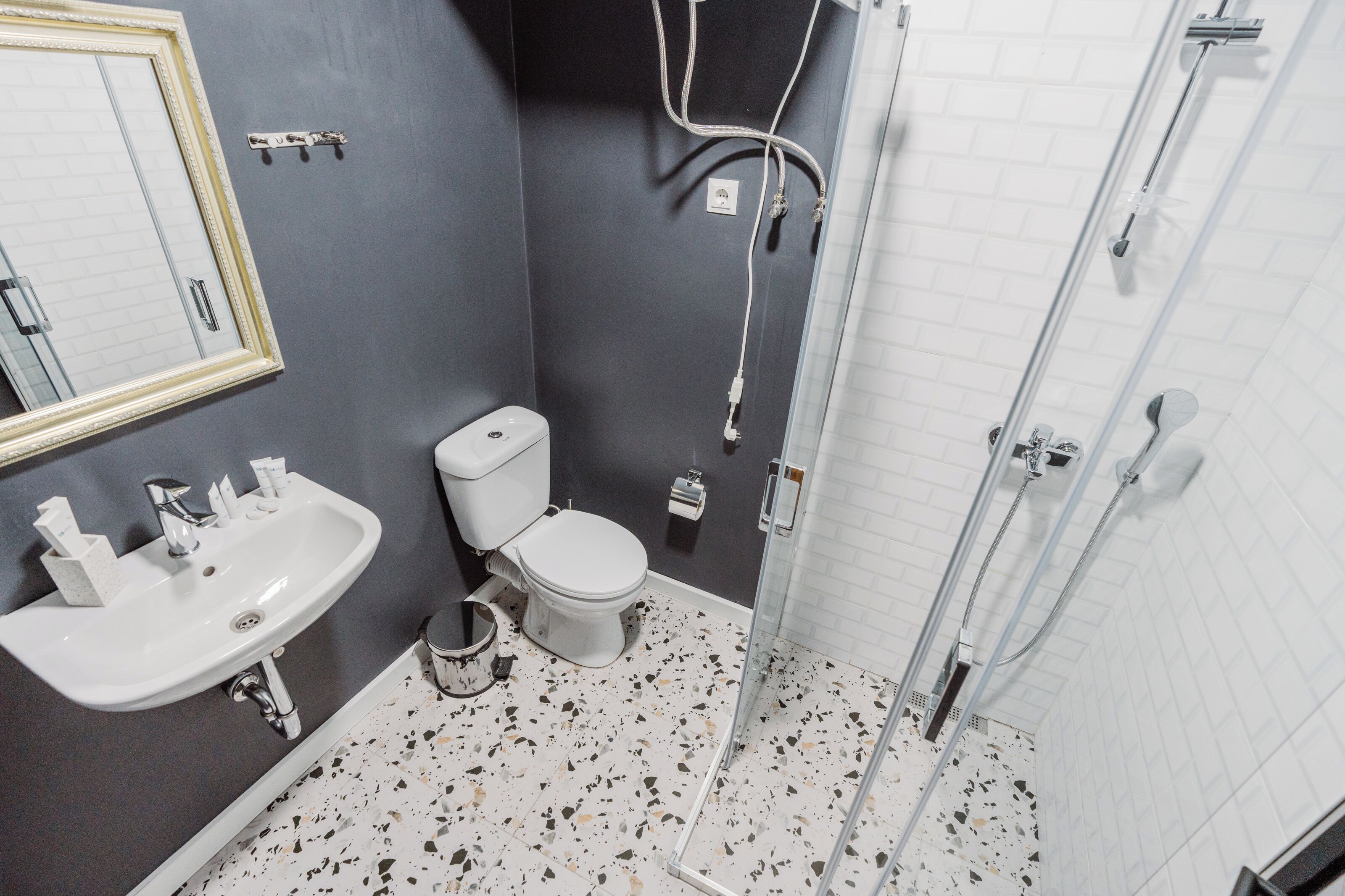 A bathroom with a white sink, a toilet, and a glass-enclosed shower.