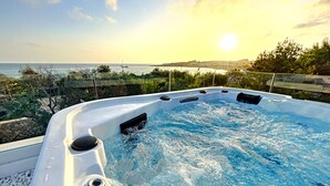 A hot tub with a view of the sea and hills during sunset. - 5-star dream villa, beach access, pool, jacuzzi (Marina di Felloniche)