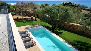 A pool with lounge chairs and a view of the sea. - 5-star dream villa, beach access, pool, jacuzzi (Marina di Felloniche)