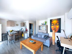 Un salon moderne comprenant un canapé, une table basse et un coin repas avec des chaises et une table.