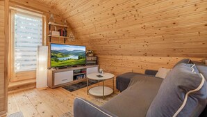 A wooden interior with a television, sofa, and bookshelves. - Log Cabin Forest Chalets (Podcetrtek)